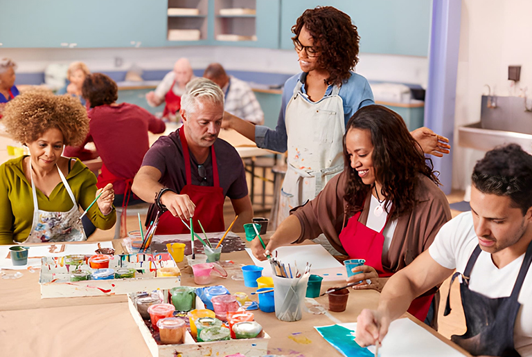 Inclusive art with diverse adults painting together in a creative workshop.