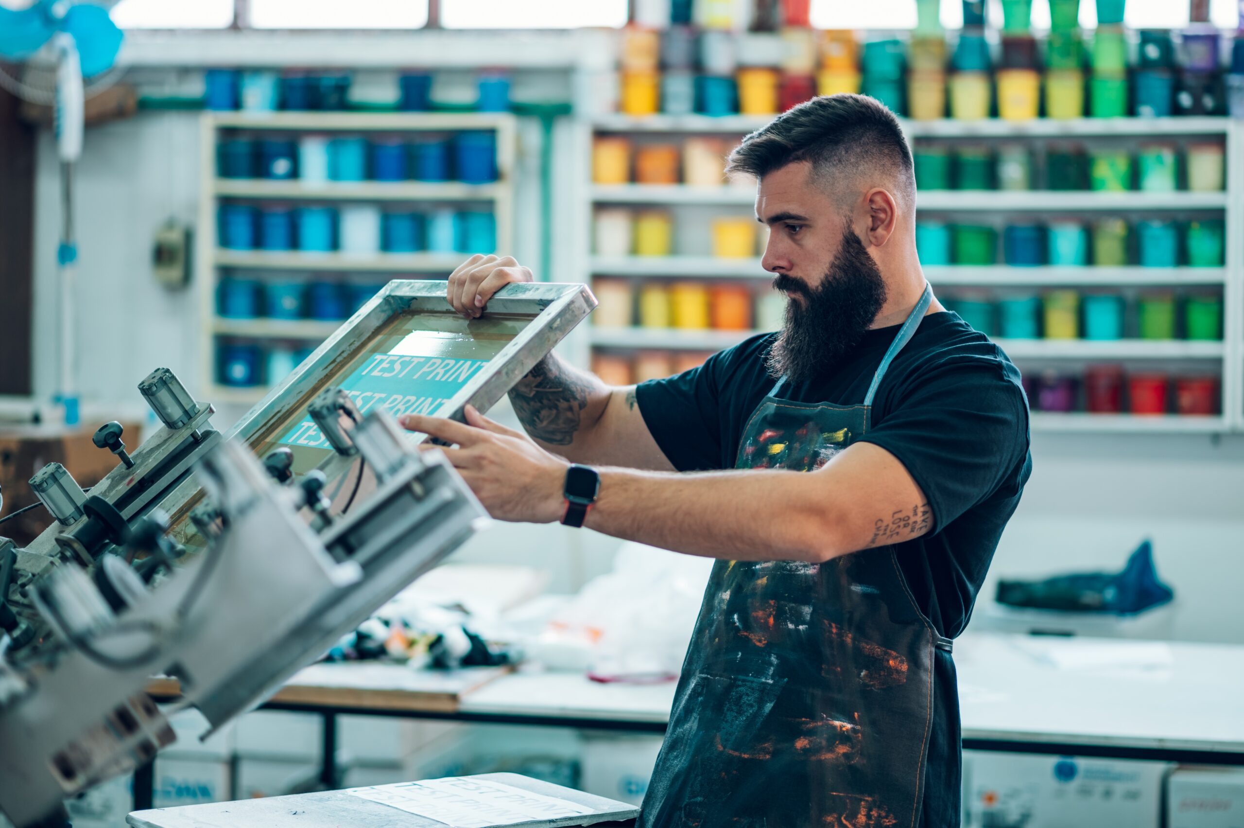 Technician adjusting screen printing frame at Sahara Oasis workshop